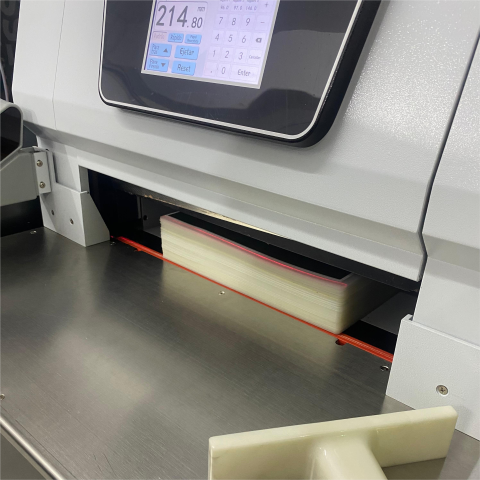 Guilhotina sendo usada para cortar papel